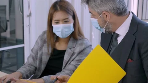 Professional caucasian boss explaining work to young asian female secretary Stock Footage 136466145