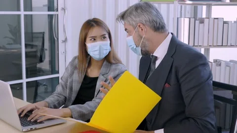 Professional caucasian boss explaining work to young asian female with mask Stock Footage 136466230