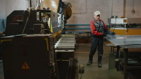 A professional Caucasian engineer is laying a sheet of metal on a cutting Stock-Footage 137605302