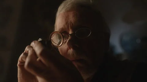 A professional checking antiques on the table using magnifying glass Stock-Footage 258294928