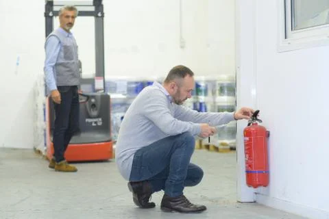 Professional checking a fire extinguisher Stock Photos