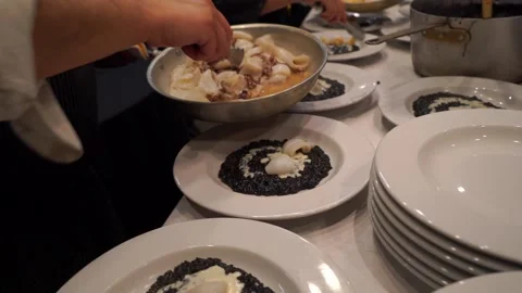 Professional chef adds seafood at squid ink risotto. Stock Footage 228655257
