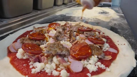 Professional Chef Applying Spicy Sauce to Fresh Italian Meat Pizza in Restaurant Stock Footage 337676618