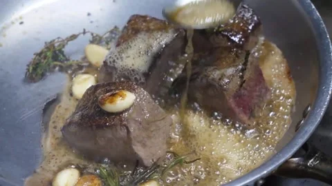 Professional Chef Basting Beef Fillet Mignon with Garlic and Herbs in Sizzling P Stock Footage 337678286