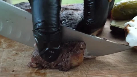 Professional chef in black gloves slicing a juicy, medium-cooked grilled beef st Video stock 338213507