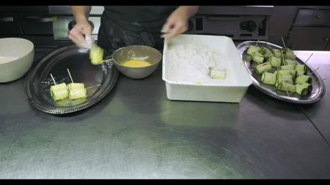 Professional chef breading zucchini rolls for frying Stock Footage 328227914