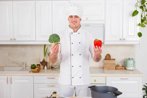 Professional chef chooses between red pepper and broccoli Stock Photos
