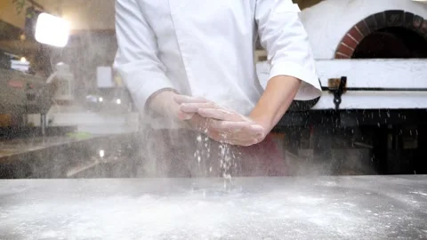 A professional chef claps his hands and the flour flies in different directions. Video stock 308243030