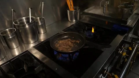 Professional Chef Cooking with High Flame Flambé Technique in Italian Restaurant Stock Footage 337678207