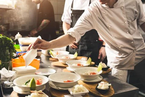 Professional chef cooking in the kitchen restaurant at the hotel, preparing Stock Photos