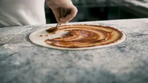 Professional chef is cooking pizza, applying delicious tomato sauce on dough Stock Footage 199214964