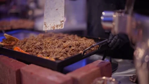 Professional chef cooking shredded meat on a large flat Stock Footage 346644488