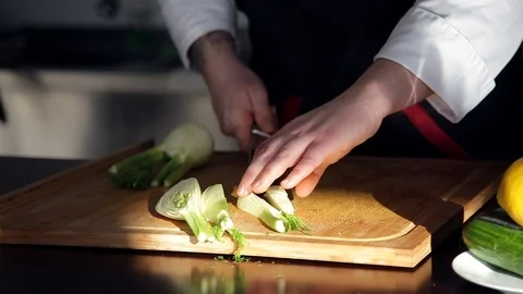 Professional chef is cutting fresh vegetables into small pieces on wooden Board. Stock Footage 88944188