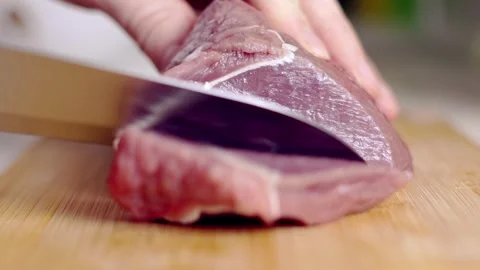 Professional Chef Cutting Raw Meat into Steaks on Wooden Cutting Board Vidéo 256603216