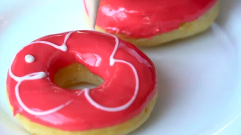 Professional chef decorates some freshly made and oily doughnuts with crimson co Stock Footage 199489339