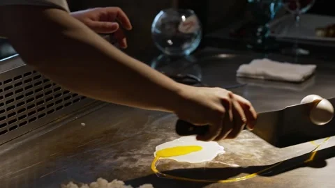 A professional chef deftly breaks an egg and prepares an omelet from fresh farm Stock Footage 277254684