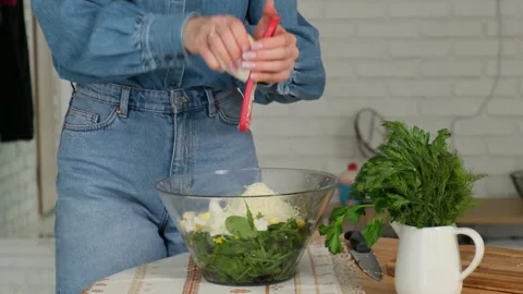 Professional chef grating parmesan cheese into a fresh green salad with spinach Видео 345048242