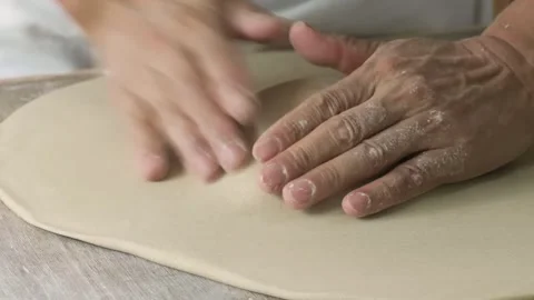 Professional Chef Hand-Stretching Fresh Pizza Dough on Wooden Table Stock Footage 333522790