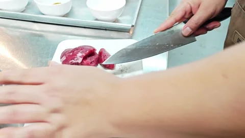Professional chef hands cutting raw meat on a chopping board. Видео 343697740