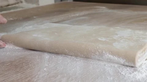 Professional Chef Hands Folding Laminated Pastry Dough on Floured Wooden Table Stockbeeldmateriaal 333522997