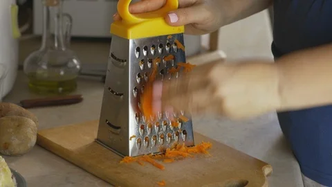 The professional chef with hands to grate carrots to prepare cookinging Stock Footage 126251845