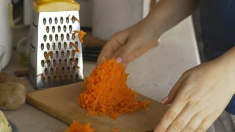 The professional chef with hands to grate carrots to prepare cookinging Stock Footage 126252171