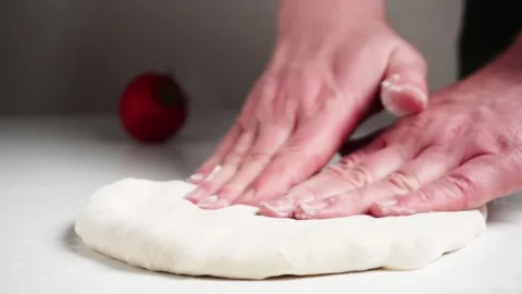 Professional chef hands stretching and flattening fresh pizza dough on a tabl Video stock 334328757