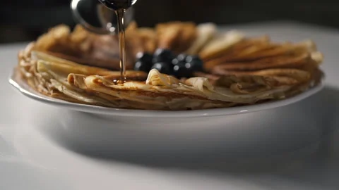 Professional Chef in Kitchen of Restaurant pours Pancakes honey or maple syrup. Vidéo 143416132