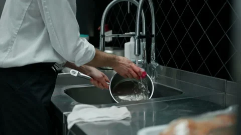 Professional chef in the kitchen washing dirty dishes in the sink after cooking Stock Footage 237914831