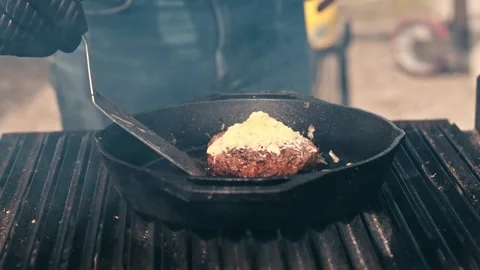 Professional chef lifts cooked beef burger patty with melted cheese from ho.. Stock Footage 339348619