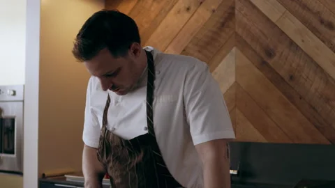 A professional chef looking up recipe and assistant peeling a beet in interior k Stock Footage 199457707
