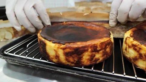 Professional Chef Peeling Parchment Paper from a Freshly Baked Basque Burnt Chee Stock Footage 331785685