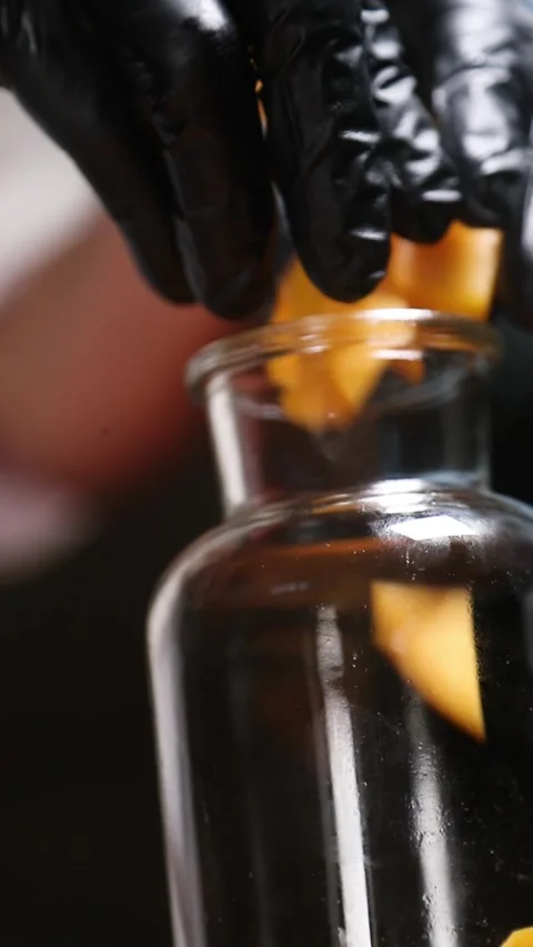 Professional chef placing peach pieces and orange peel into a glass jar for.. Stock Footage 335653530