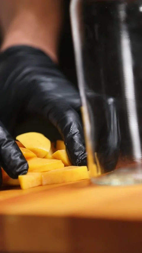 Professional chef placing peach pieces and orange peel into a glass jar for.. Stock Footage 335653532