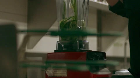 Professional chef placing ribbons of cucumber into a blender in industrial kitch Video stock 199457907