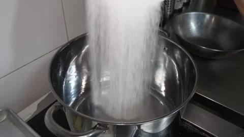 Professional Chef Pouring White Salt Granules into Stainless Steel Pot Close-up Видео 338212417