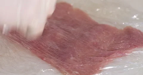 A professional chef prepares a dish of raw meat by beating it Stock Footage 145561207