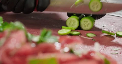 Professional chef prepares healthy vegetable salad, chops cucumber on a cutting Stock Footage 286834777
