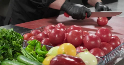 Professional chef prepares healthy vegetable salad, put tomato on a cutting Stock Footage 286837244