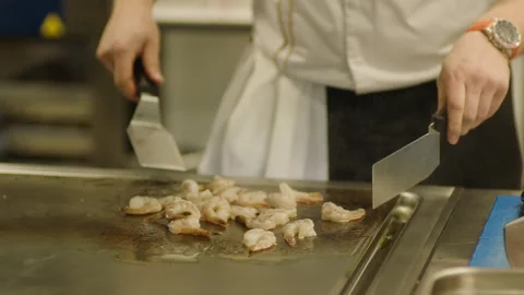 A professional chef prepares shrimp in the restaurant kitchen. Professional Video stock 232562364