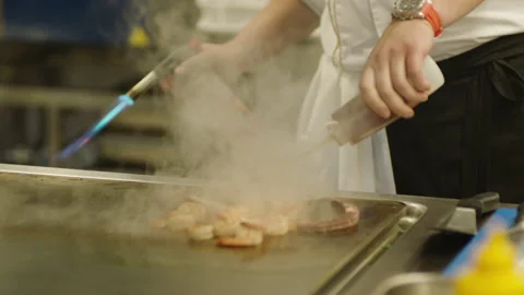 A professional chef prepares shrimp in the restaurant kitchen. Professional Video stock 232562585