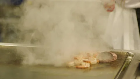 A professional chef prepares shrimp in the restaurant kitchen. Professional Stock Footage 232562668