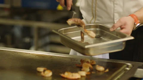 A professional chef prepares shrimp in the restaurant kitchen. Professional Stock Footage 232562698