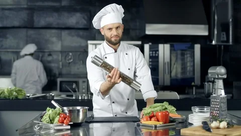 Professional chef preparing to cook at kitchen. Chef warming up with pepperbox Vidéo 108377911