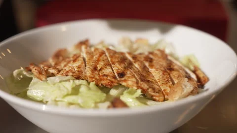 Professional chef preparing a delicious chicken caesar salad with lettuce Stock Footage 338392754