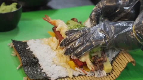 Professional Chef Preparing Large Sushi Roll with Tempura and Fresh Ingredients Stock Footage 333570388