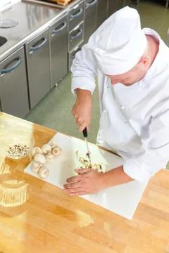 Professional chef preparing mushrooms in large kitchen Stock Photos