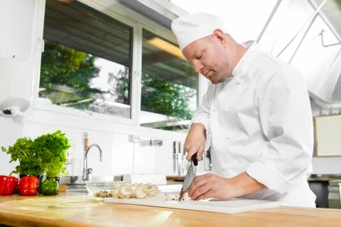 Professional chef preparing vegetables in large kitchen Stock Photos