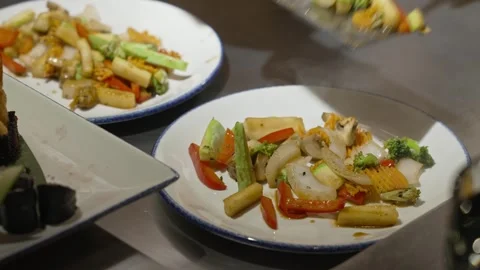 A professional chef puts fried vegetables on a plate Stock Footage 278590370