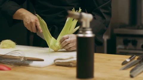 Professional chef removing ears of corn from cob in industrial kitchen with soft Stock Footage 199463673